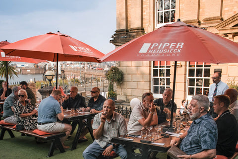 Guests seated on the open terrace at El Puerto, Penarth Marina, smoking Davidoff Millennium Piramides cigars during the Toro Puro tasting evening