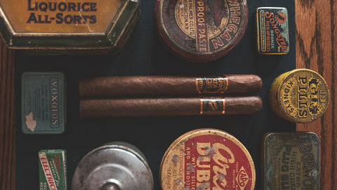 Collection of vintage tins and cigars on a wooden surface