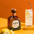 Bottle of Don Julio Reposado tequila beside two tall iced cocktails with lemon slices, served at the Toro Puro cigar and tequila tasting evening