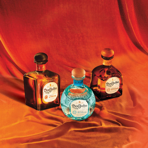 Three bottles of Don Julio tequila, Añejo, Blanco and Reposado, displayed on draped orange velvet for the Toro Puro guided tequila and cigar pairing