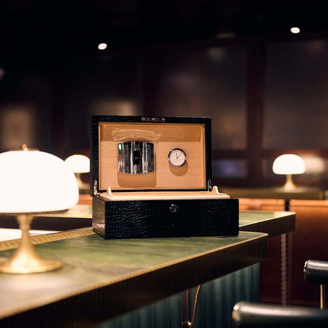 Rapport Brompton black medium humidor open on a bar counter in a moody lounge setting - Toro Puro