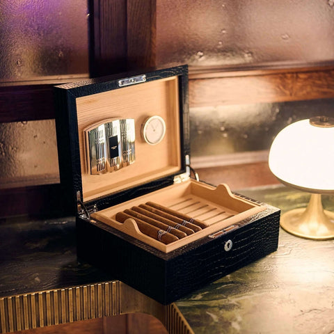 Rapport Brompton black medium humidor open with cigars laid in the tray, warm lounge lighting - Toro Puro