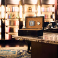 Rapport Brompton black medium humidor open on a marble table, library bar setting in the background - Toro Puro