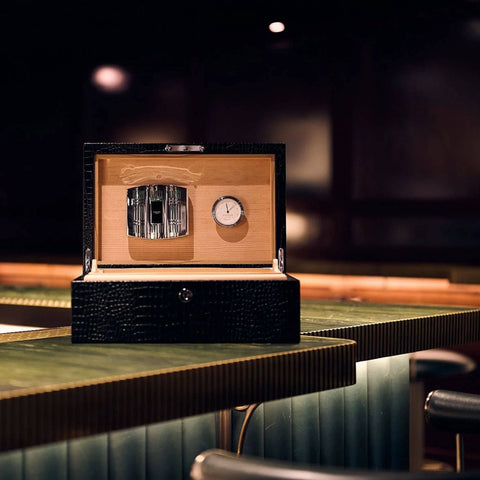 Rapport Brompton black medium humidor on a bar top, wider view of the lounge setting - Toro Puro