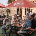 Guests enjoying cigars and drinks at a Toro Puro cigar tasting event on an outdoor terrace in South Wales
